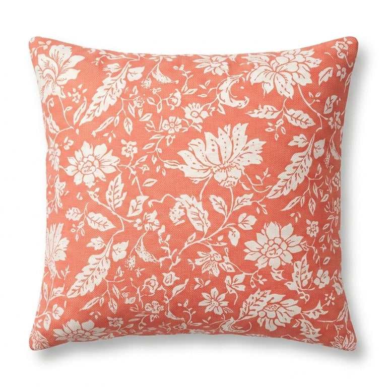Coral pillow with white floral pattern on a white background