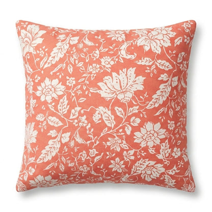 Coral pillow with white floral pattern on a white background