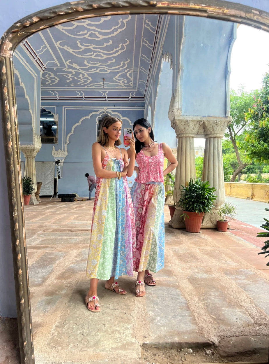 Two women taking a mirror selfie in a decorative outdoor setting.